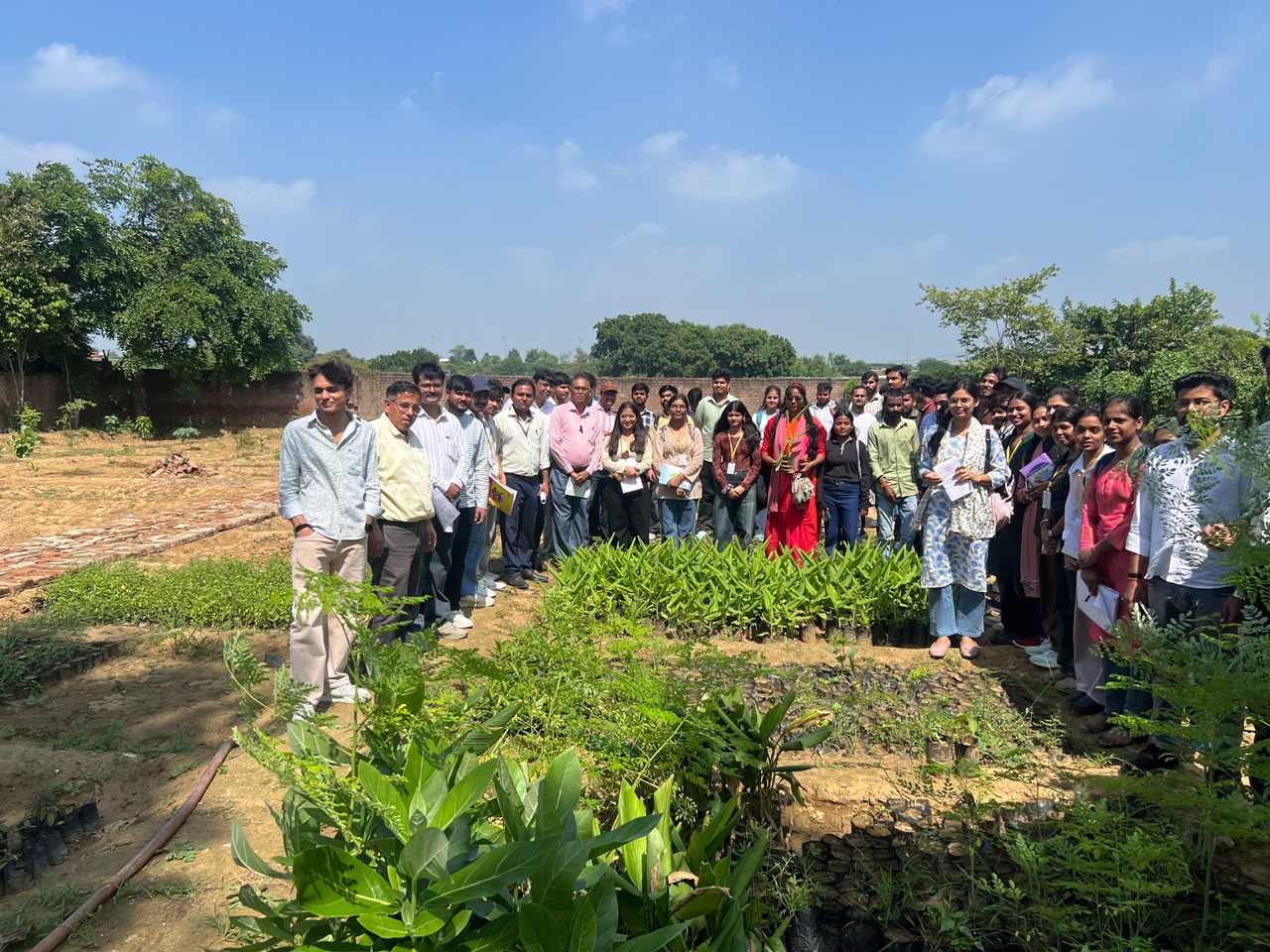 Student group gathered beside planted garden beds